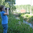 Ainsley looks for polar bears across the stream with the 'noculars.